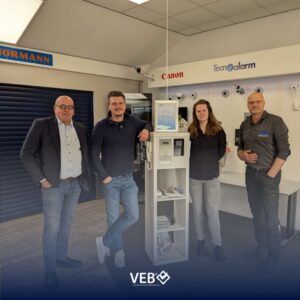 VEB op bezoek bij trotse leden in beveiligingsshowroom met certificaat zichtbaar.